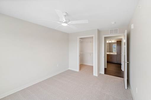 a renovated living room with white walls and a ceiling fan