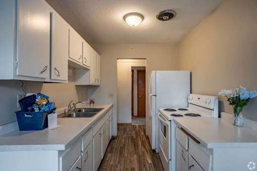 A kitchen with white appliances and cabinets.