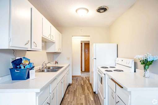 A kitchen with white appliances and cabinets.