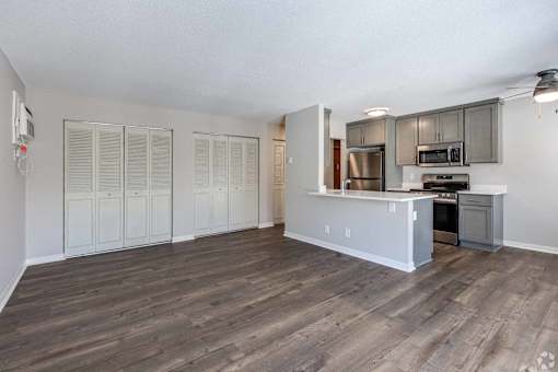 A kitchen with a refrigerator, oven, and microwave.