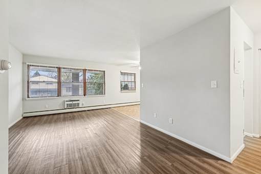 A room with wooden flooring and white walls.