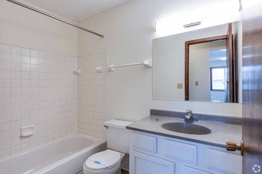 A white bathroom with a toilet, sink, and bathtub.