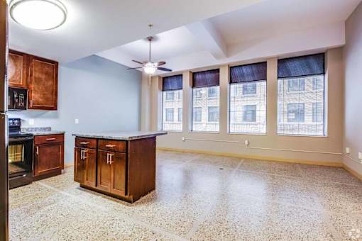 A kitchen with a marble floor and wooden cabinets.