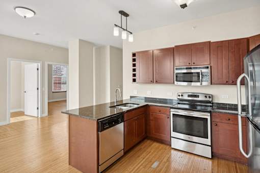 an empty kitchen with wooden cabinets and stainless steel appliances