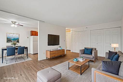 A living room with a grey couch, a wooden coffee table, and a painting on the wall.