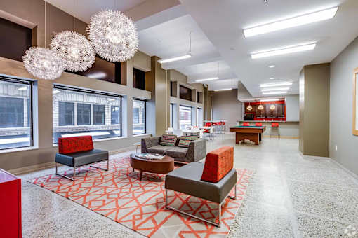 A spacious living room with a red and grey patterned carpet.