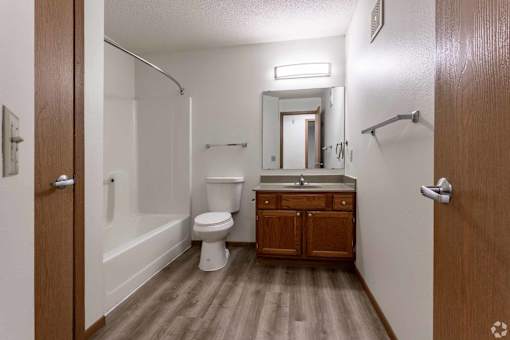 A small bathroom with a toilet, sink and a mirror.