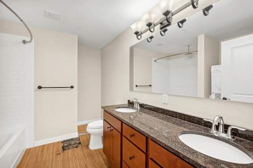 a bathroom with two sinks and a mirror and a toilet