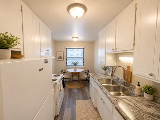 A kitchen with white cabinets and a washer and dryer.