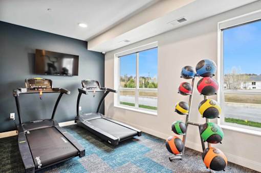 a gym with two treadmills and a tv on the wall