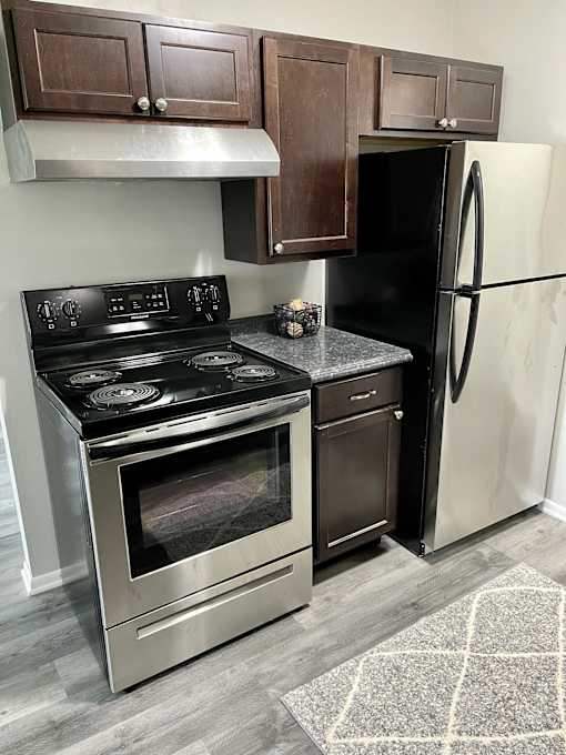 A kitchen with a stove, oven, and refrigerator.