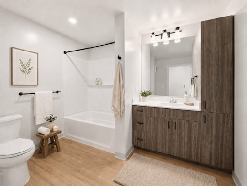 A bathroom with a white toilet, a white bathtub, a wooden cabinet, and a mirror.