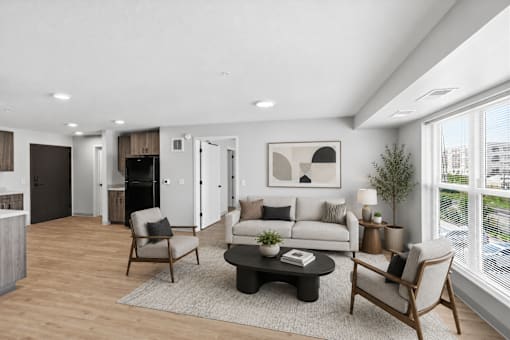 A modern living room with a grey sofa, a wooden coffee table, and a large window.
