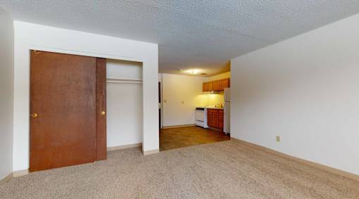 A room with a brown door and a white wall.
