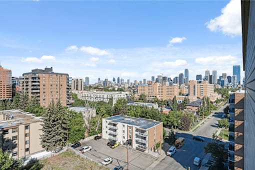 A cityscape with buildings and cars on the street.