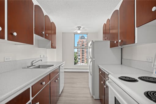 A kitchen with brown cabinets and a white stove top oven.
