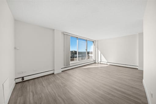 A room with a large window and wooden flooring.