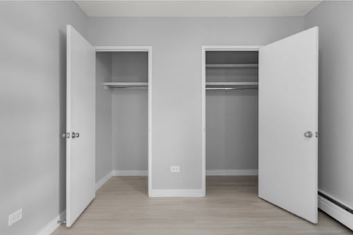 Two white closet doors with shelves inside.
