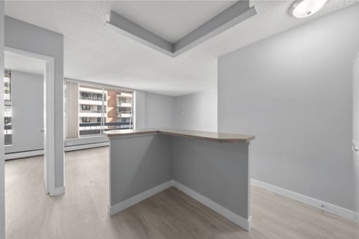 A spacious room with a grey wall and a wooden counter.