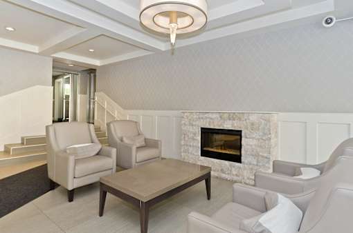 A living room with a fireplace and two chairs.