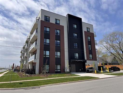 A modern apartment building with balconies and a black entrance.
