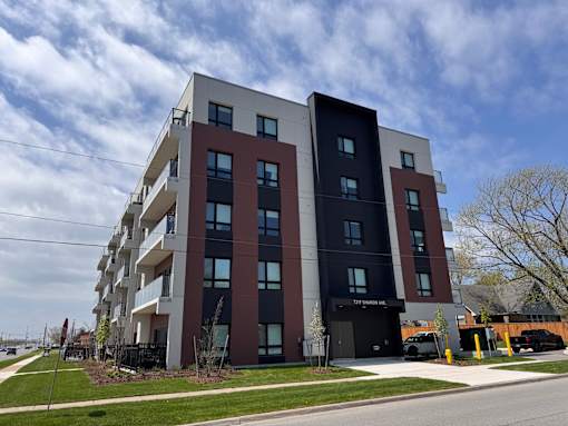 A modern apartment building with balconies and a black entrance.