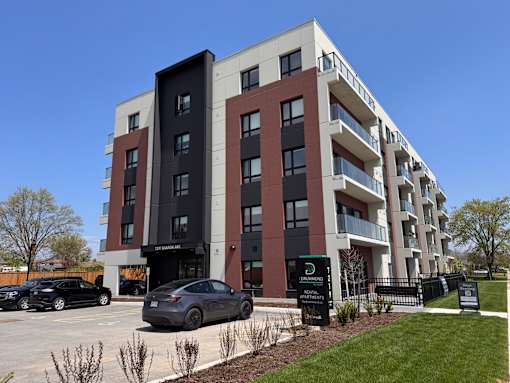A modern apartment building with cars parked in front.