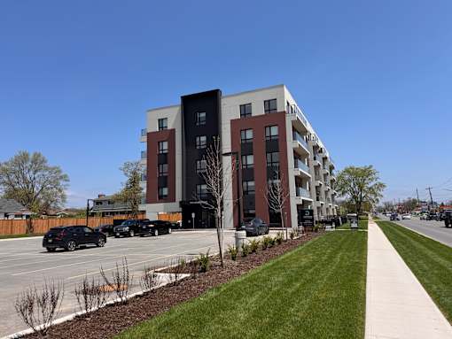 A modern apartment building with cars parked in front.