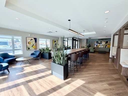 A spacious room with wooden floors and a bar area.