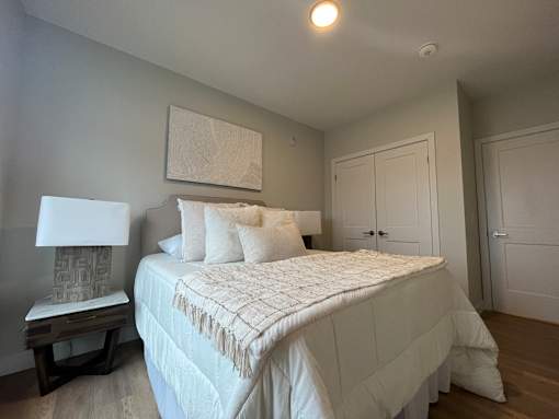 A bedroom with a large bed and a painting on the wall.