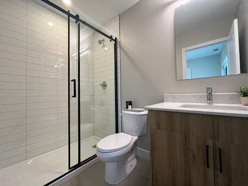 A white toilet sits next to a sink in a modern bathroom.