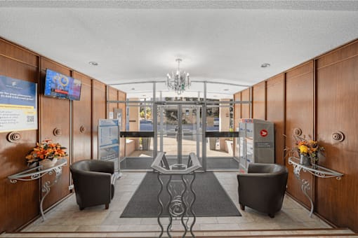 A reception area with a glass door and a chandelier.