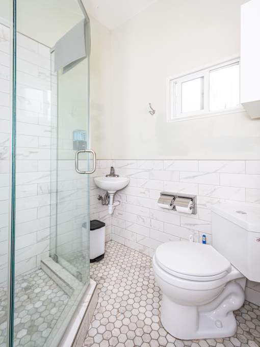 A white toilet in a bathroom with a glass shower door.