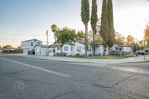 A street view of a residential area with houses and trees.