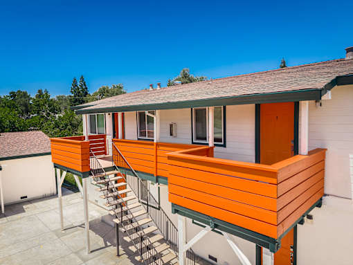 A house with orange wooden balconies and a grey roof.
