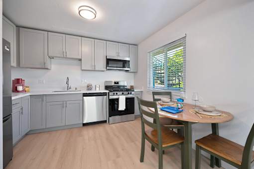 A kitchen with a table and chairs.
