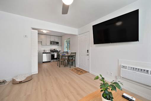 A living room with a flat screen TV mounted on the wall.