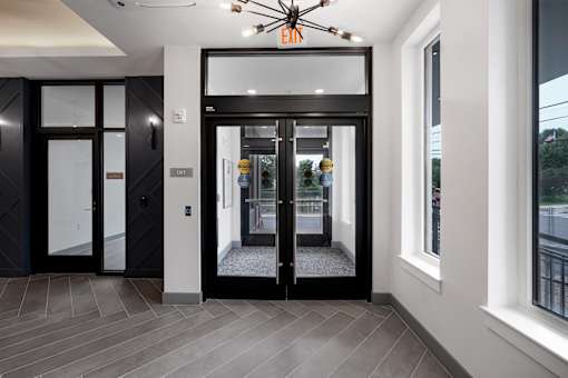 A black door with a glass window is in the center of the image.