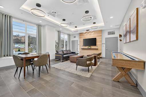 A modern living room with a pool table and a television.