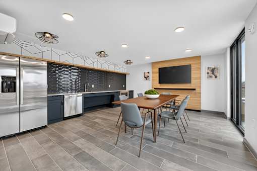 A modern kitchen with a dining table and chairs.