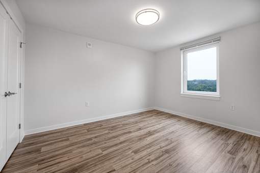 A room with a window and wooden flooring.