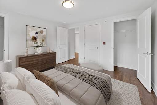 A bedroom with a bed, dresser, and a painting on the wall.