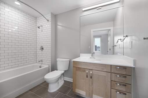 A white bathroom with a toilet, sink, and bathtub.