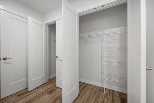 A white closet with shelves and a door.
