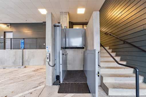 A staircase with a metal railing leads to a set of stairs with a black handrail.
