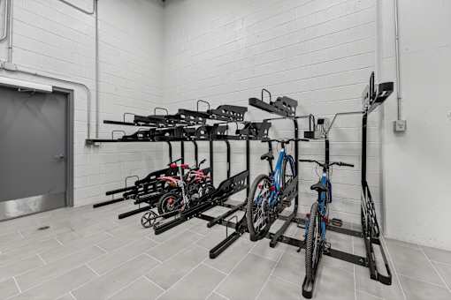 A row of bicycles are parked in a garage.