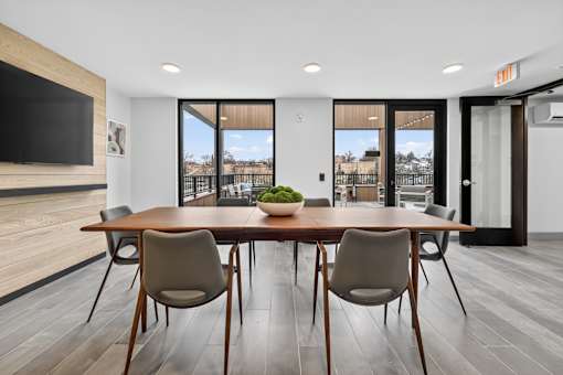A modern dining room with a wooden table and chairs.