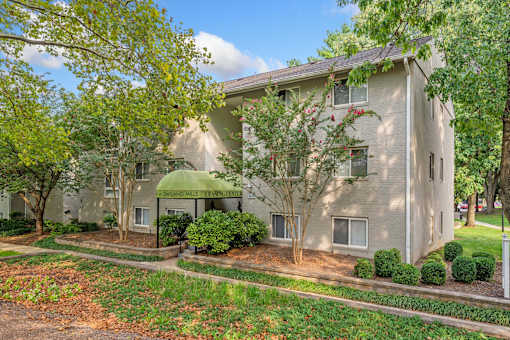 A building with a green awning and a sign that says "Congdon Woods Apartments".
