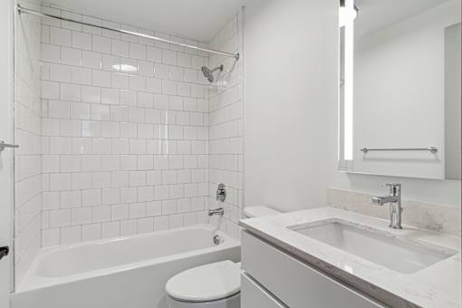 A white bathroom with a tub, toilet, and sink.