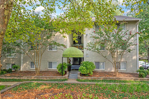 A building with a green awning and a tree in front of it.